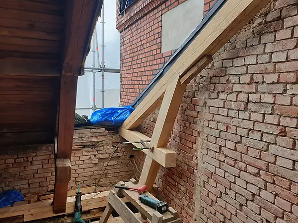 Snickeriarbete vid tegelvägg och takfot under renovering.